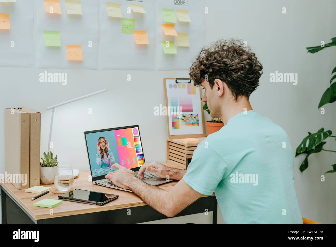 Web designer working on laptop at desk Stock Photo