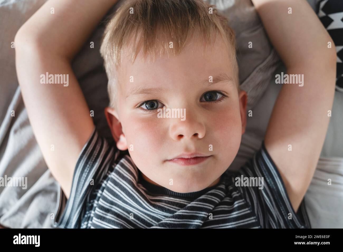 Boy lying on bed at home Stock Photo Alamy