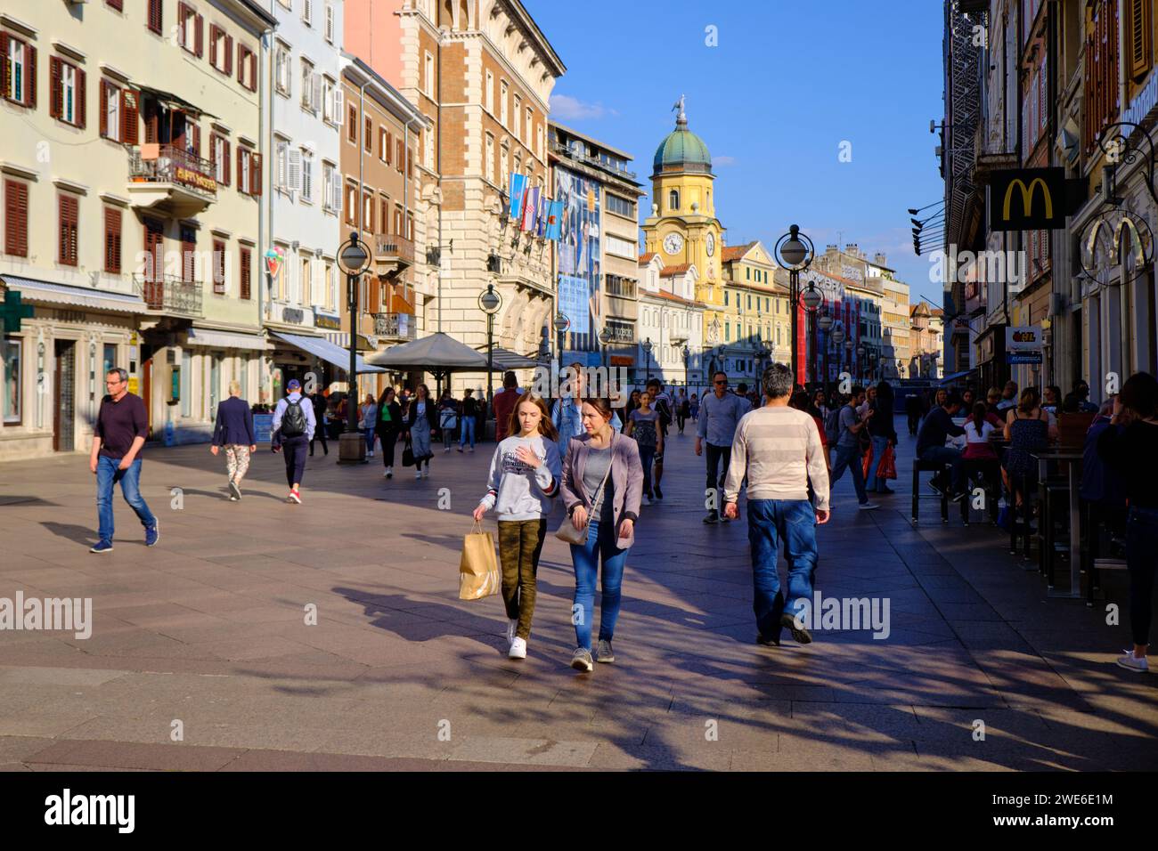 Crowd walking on Korzo, Rijeka's main pedestrian street lined with cafes and shops on sunny spring day Stock Photo