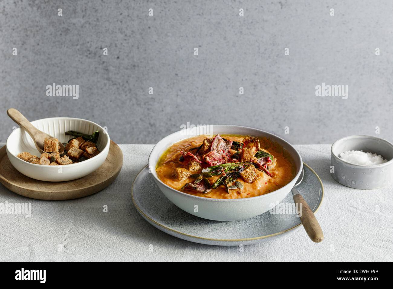 Studio shot of bowl of ready-to-eat pumpkin soup with croutons and beetroot chips Stock Photo