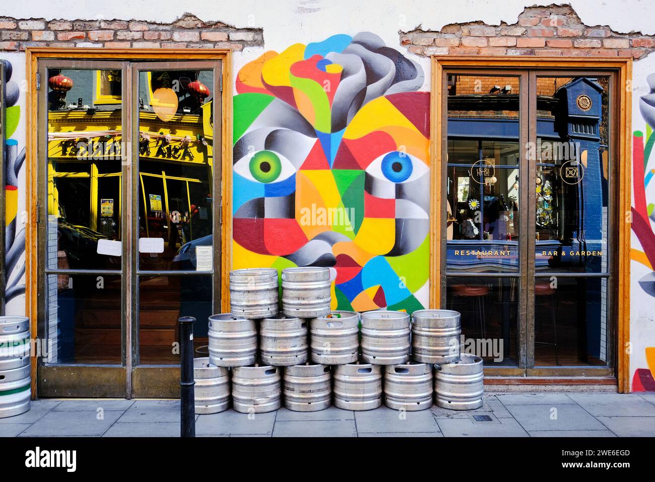 Cubist wall art, between two restaurant windows with a pile of beer
