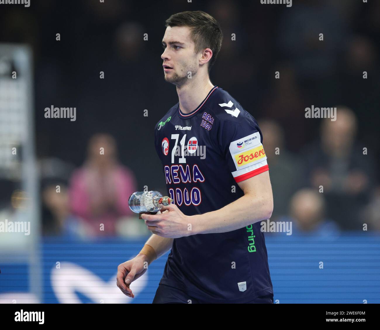Hamburg, Germany. 23rd Jan, 2024. Handball: European Championship, Norway - Sweden, Main Round, Group 2, Matchday 4, Barclaycard Arena. Norway's Alexander Christoffersen Blonz walks off the court with the 'Player of the Match' award. Credit: Christian Charisius/dpa/Alamy Live News Stock Photo