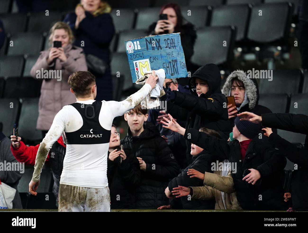 Milton Keynes Dons' Max Dean gives his shirt to a fan in the stands