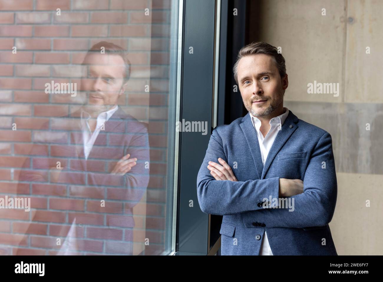 Confident businessman with arms crossed standing in workplace Stock ...