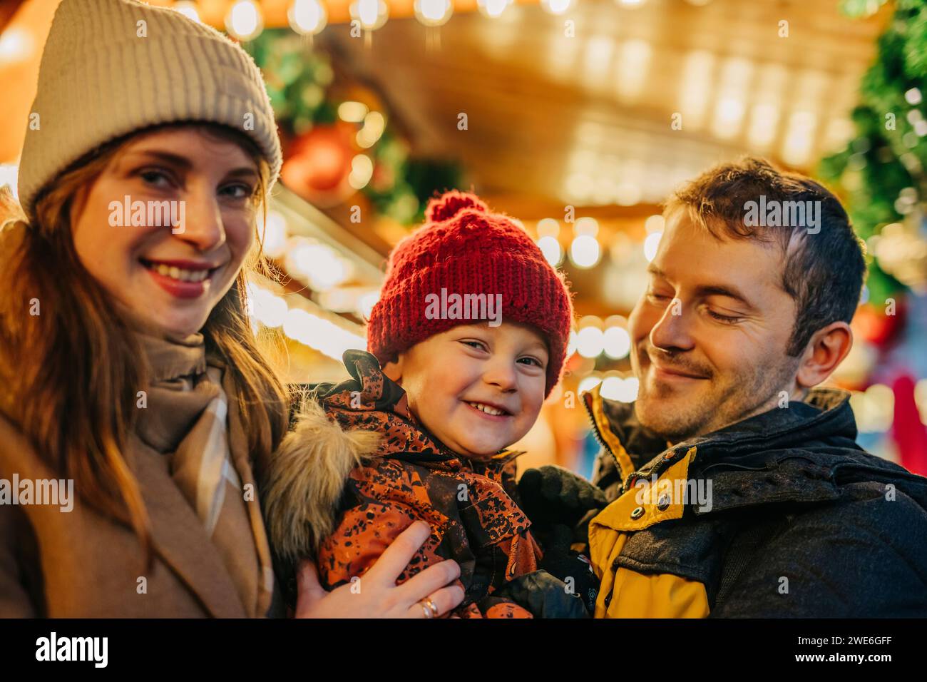 Parents spending leisure time together with son at Christmas market Stock Photo