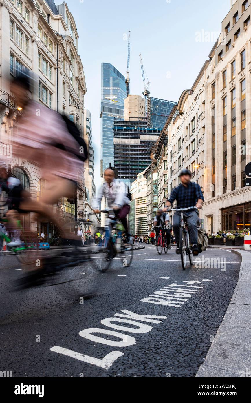 People cycling on road in city of London, UK Stock Photo