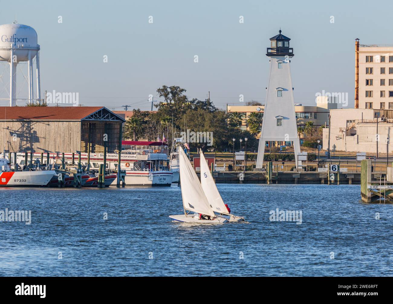 Two male youth sailing on Laser sailboats in the Gulf of Mexico at