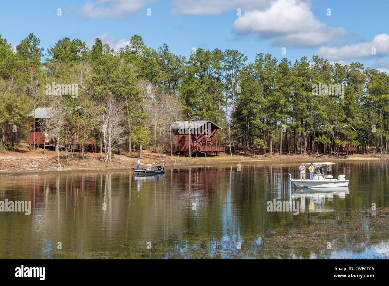 Park visitors fish in the reservoir in front of rental cabins at Flint