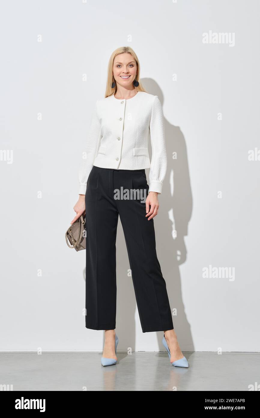Full length portrait of stylish businesswoman in wide trousers and short blazer Stock Photo
