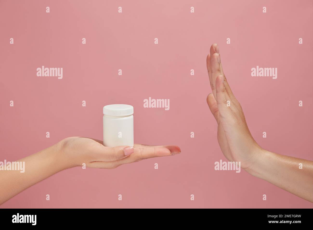 One hand acting like they are rejecting the medicine bottle in white ...