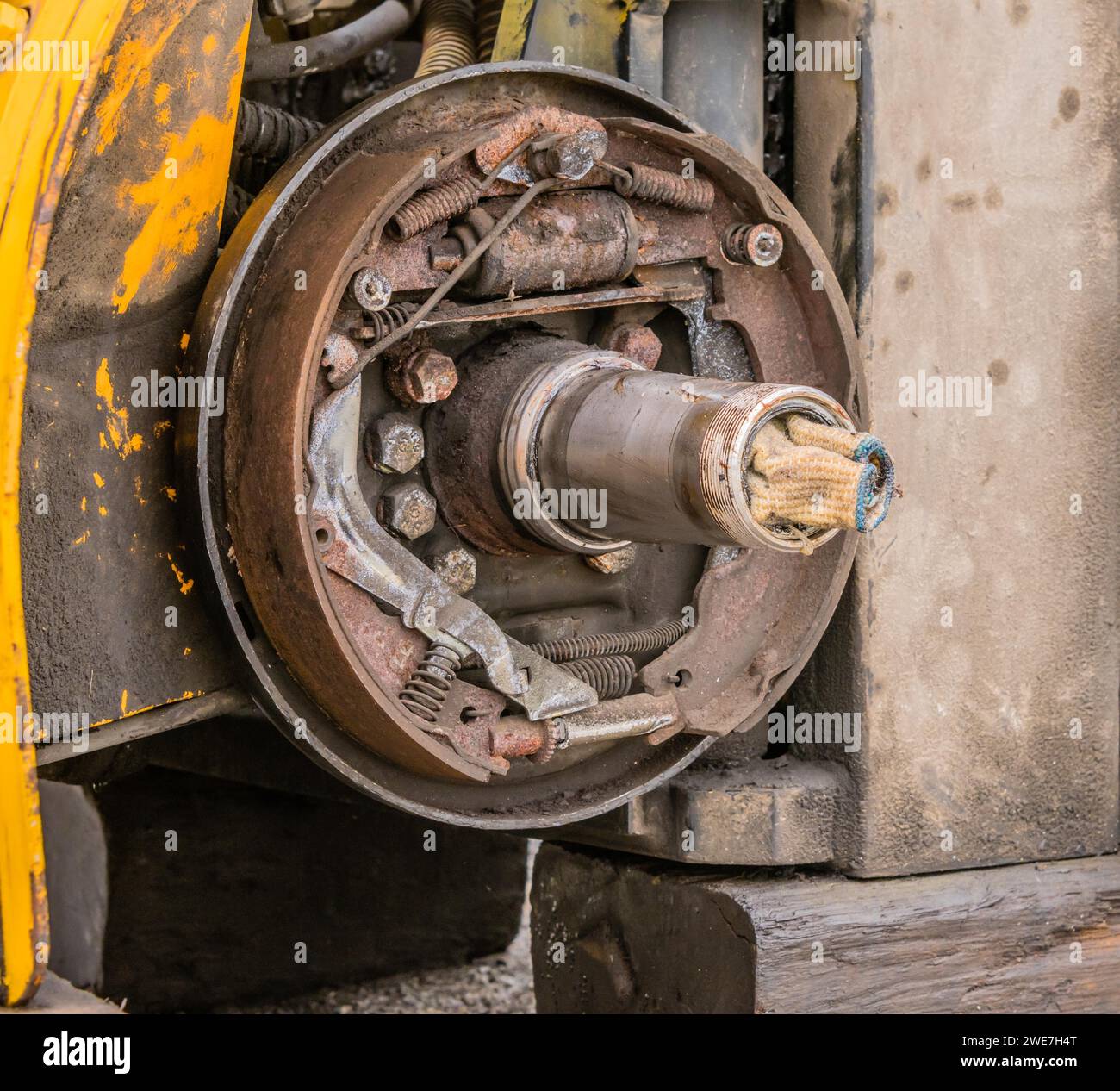 Closeup view of exposed rusty break shoe assembly and axle with dirty white cloth stuffed into open end of axle in South Korea Stock Photo