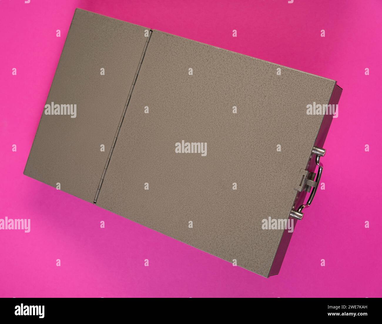 Cash box of a bank safe deposit box in front of a monochrome pink background Stock Photo