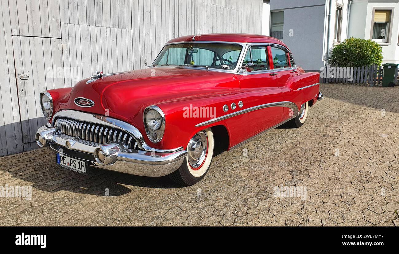 A shiny red classic car with chrome details parked in front of a white garage door, classic car, Buick Eight, Ilsede, Peine district, Lower Saxony Stock Photo