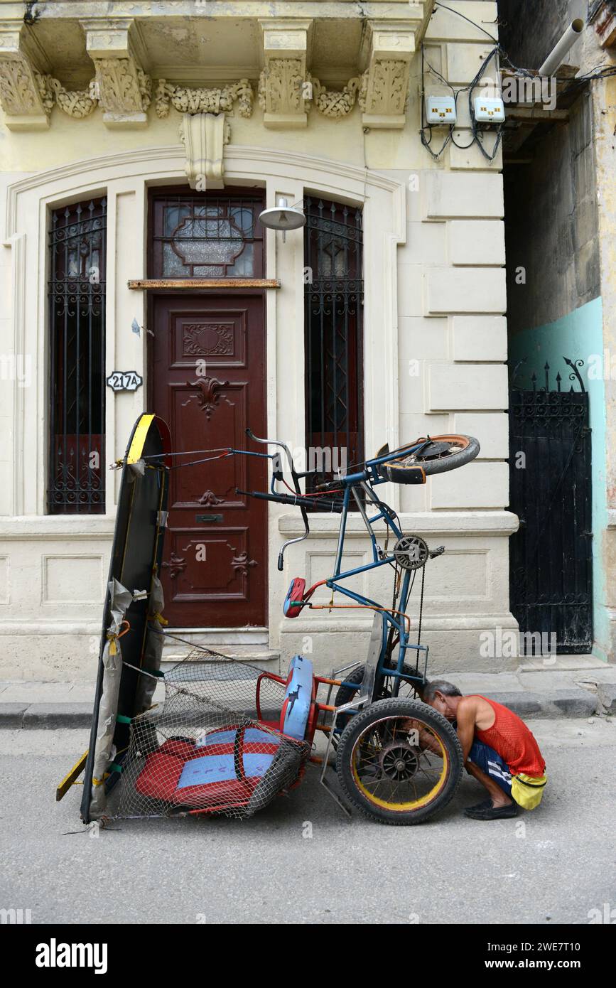 A man fixing his BIci Taxi in old Havana, Cuba. Stock Photo