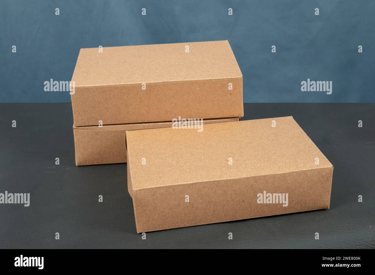 Cardboard boxes on a black table, isolated on a dark background Stock Photo