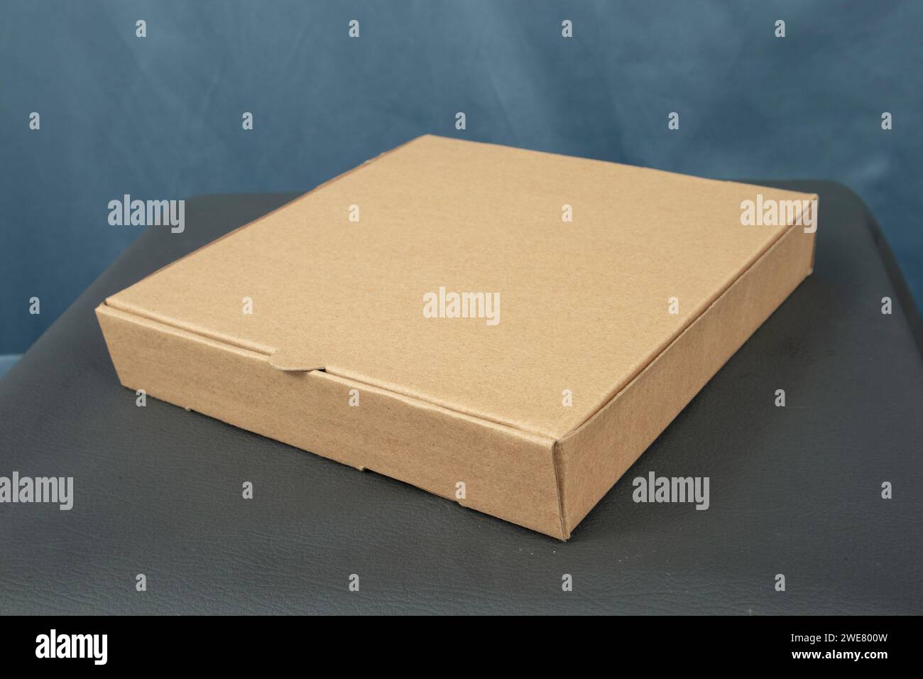 Cardboard boxes on a black table, isolated on a dark background Stock Photo