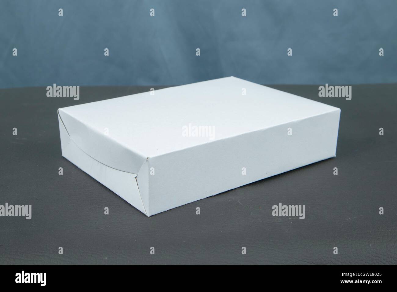 Cardboard boxes on a black table, isolated on a dark background Stock Photo
