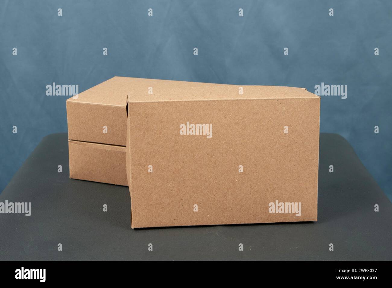 Cardboard boxes on a black table, isolated on a dark background Stock Photo