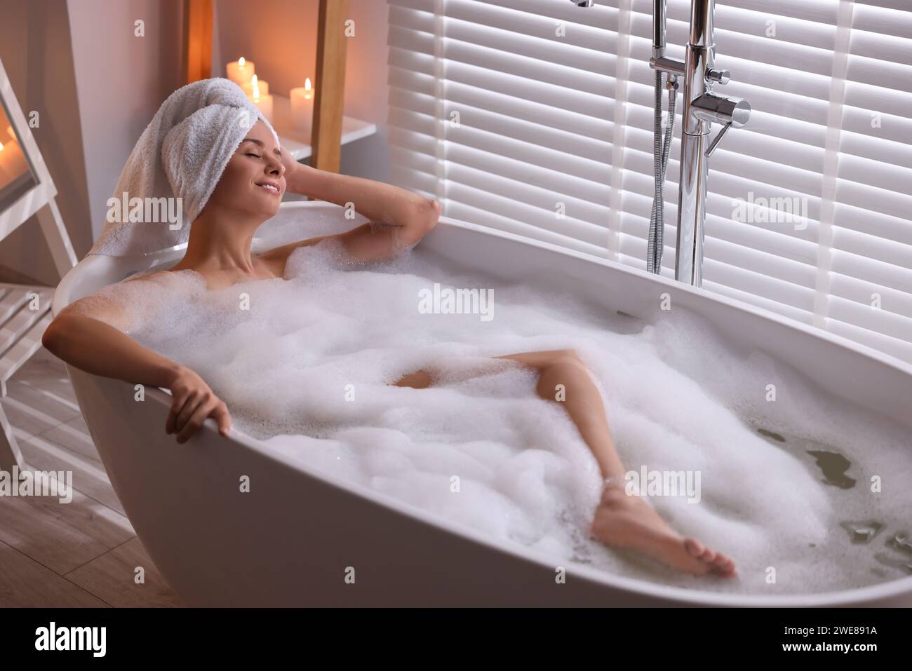Beautiful Woman Taking Bath In Tub With Foam Indoors Romantic beautiful-woman-taking-bath-in-tub-with-foam-indoors-romantic