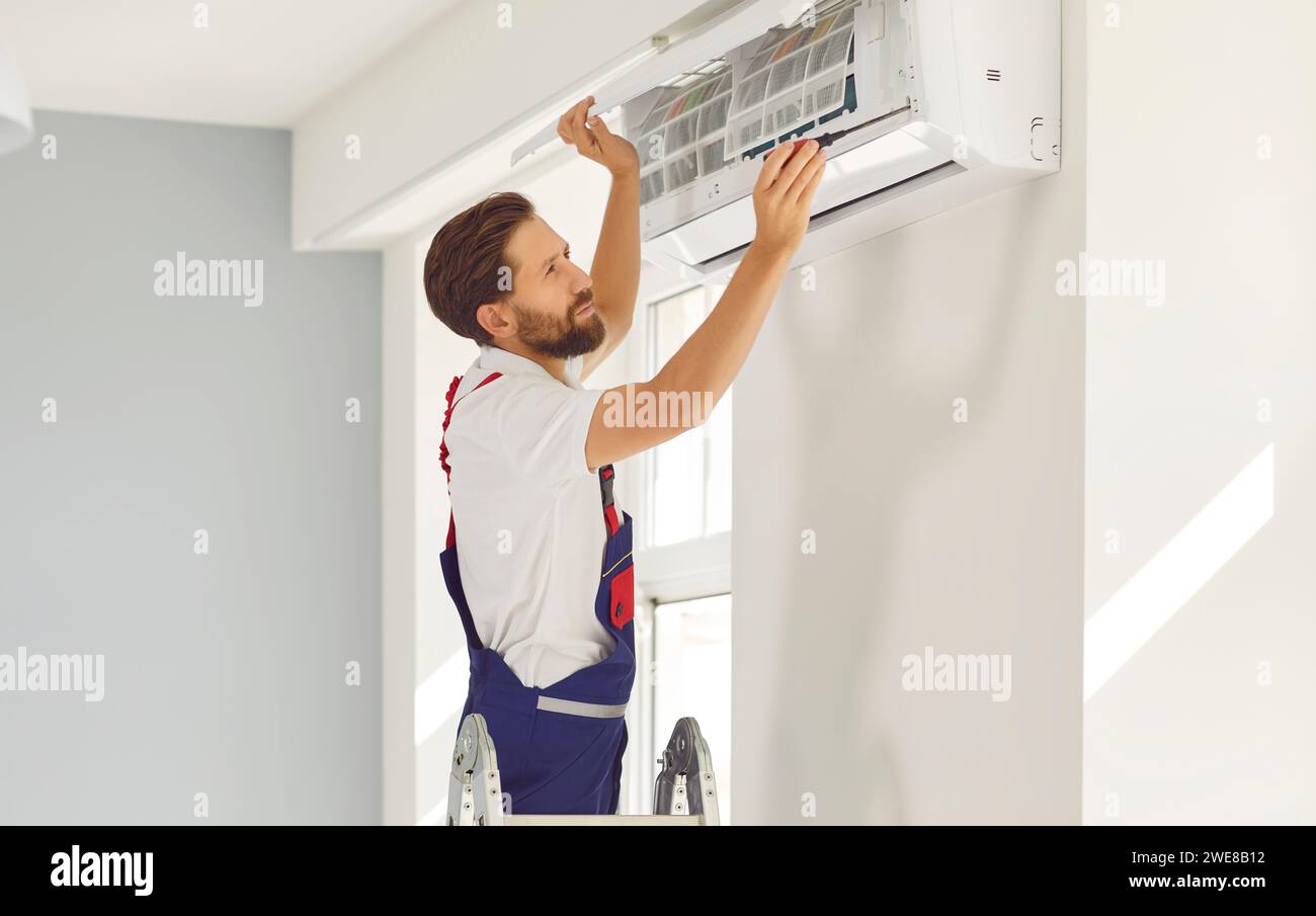 professional-male-air-conditioner-cleaner-opens-front-cover-to-clean
