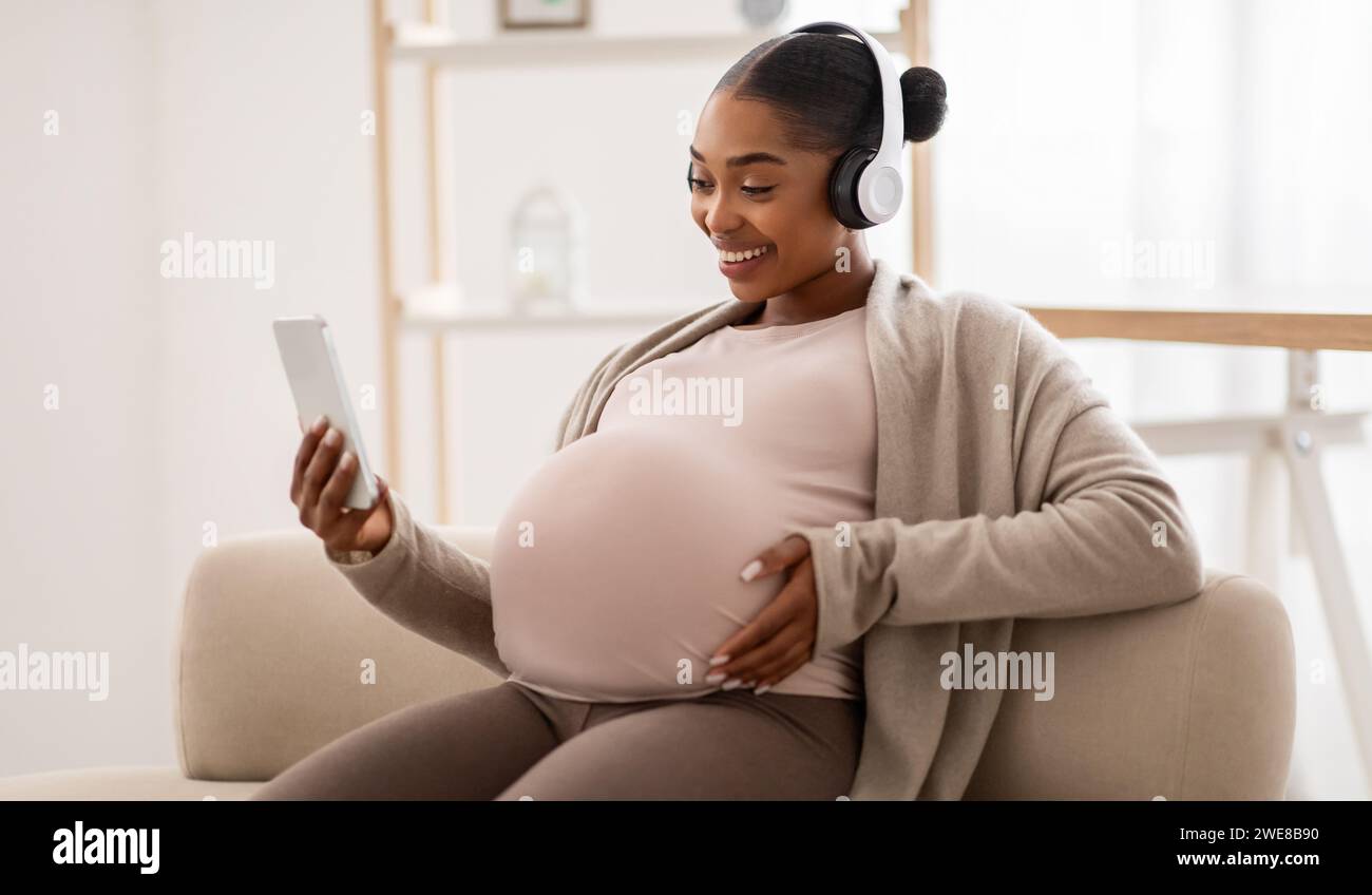 Happy pregnant black woman listening to music Stock Photo - Alamy