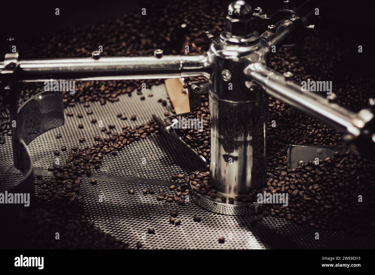 Close up of beans in a stainless steel industrial coffee roaster for an artisan coffee maker. Stock Photo