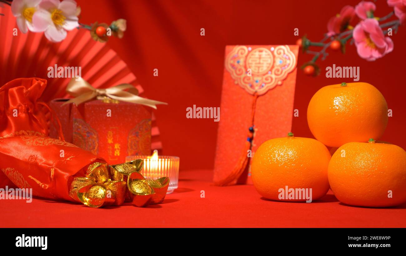 Chinese Lunar New Year background, red theme. gold in silk bag, red gift box with golden bow, paper fan, Tae Eia envelope (red envelope), orange, plum Stock Photo