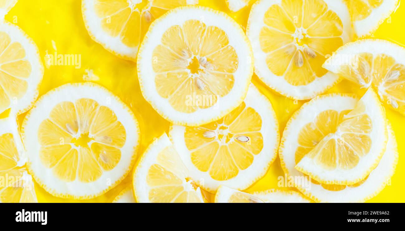 Lemon citrus slices in water, bold yellow texture summer background ...