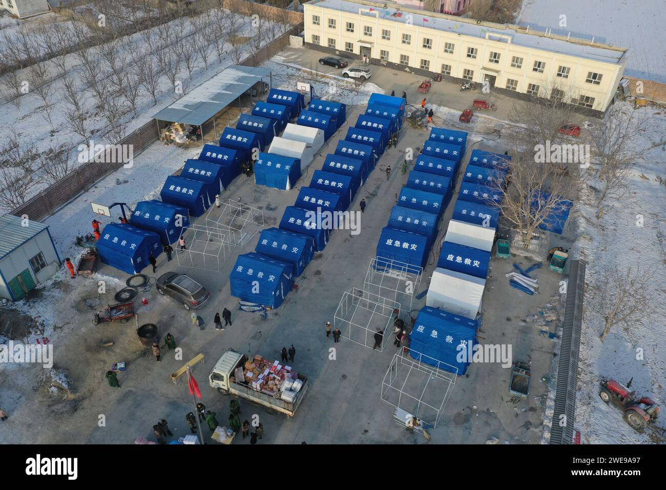 (240124) -- WUSHI, Jan. 24, 2024 (Xinhua) -- An aerial drone photo shows staff members setting up tents at a resettlement site in Wushi County, northwest China's Xinjiang Uygur Autonomous Region, Jan. 24, 2024. Three people were killed and five others injured when a 7.1-magnitude earthquake jolted Wushi County and its surrounding areas in Aksu Prefecture, northwest China's Xinjiang Uygur Autonomous Region, at 2:09 a.m. Tuesday, local authorities said. Organized rescue efforts are carried out in an orderly manner, with 12,426 people having been relocated to safe places. (Xinhua/Su Chuanyi) Stock Photo
