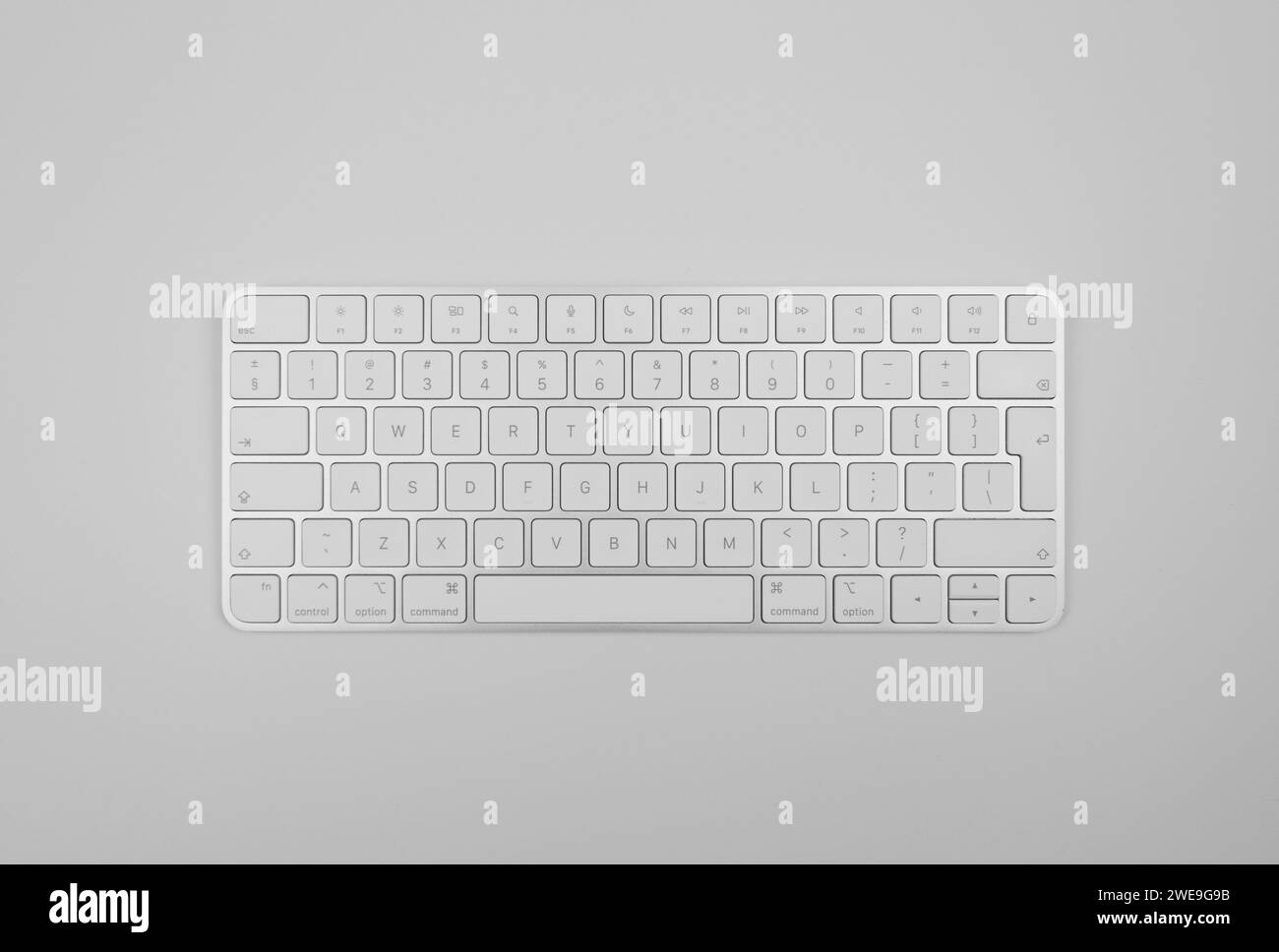 Top view of white keyboard on light grey background. Modern office flat lay, copy space. Stock Photo