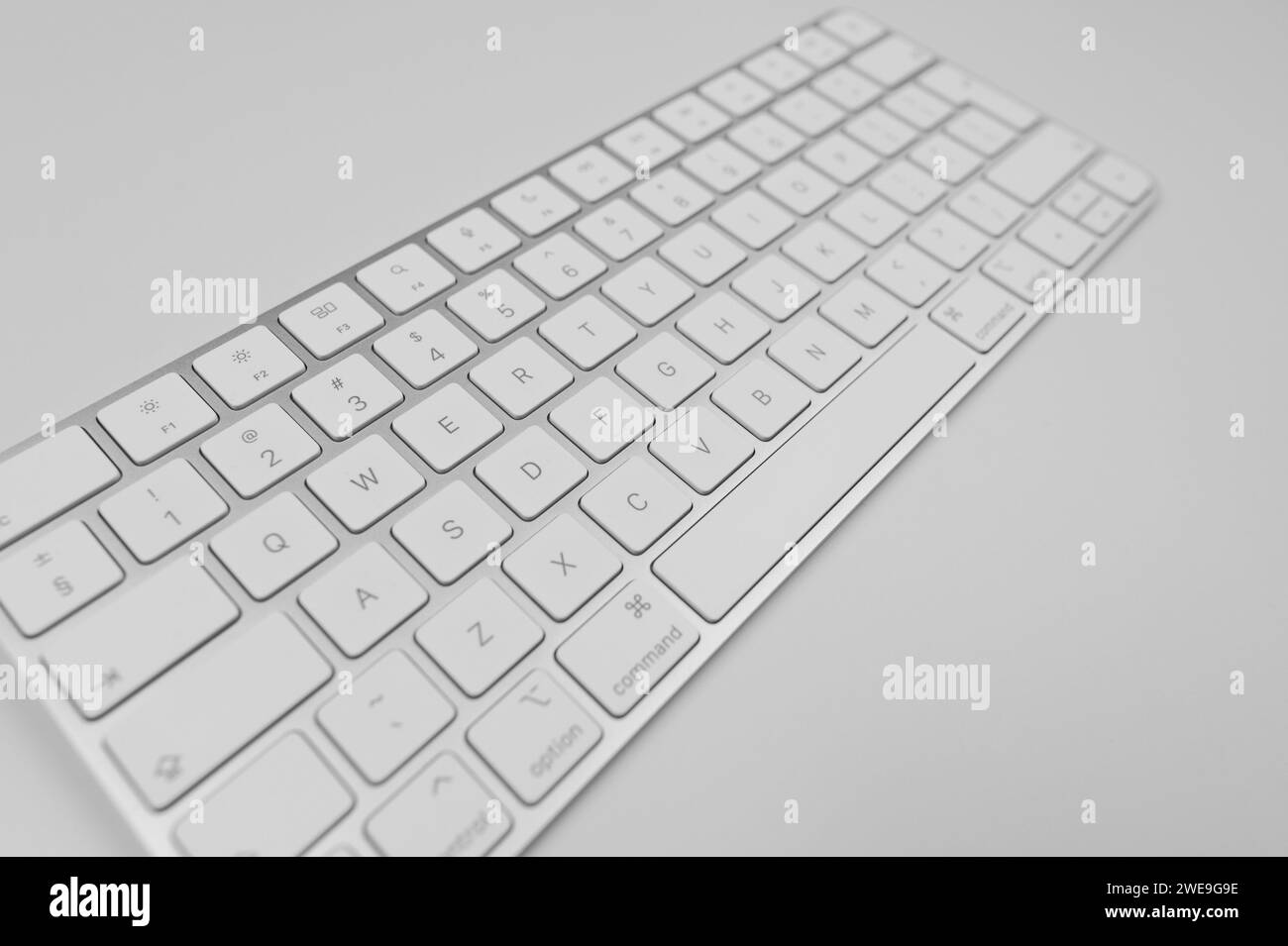 White keyboard on light grey background. Modern office, copy space. Stock Photo