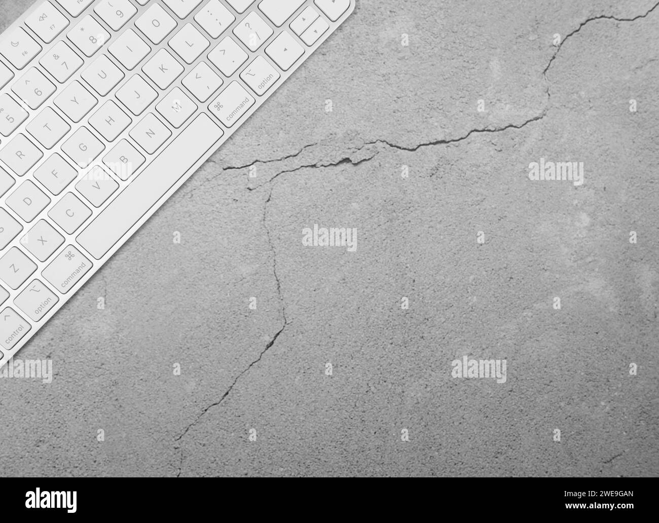 Top view of white keyboard on concrete background. Modern office flat lay, copy space. Stock Photo