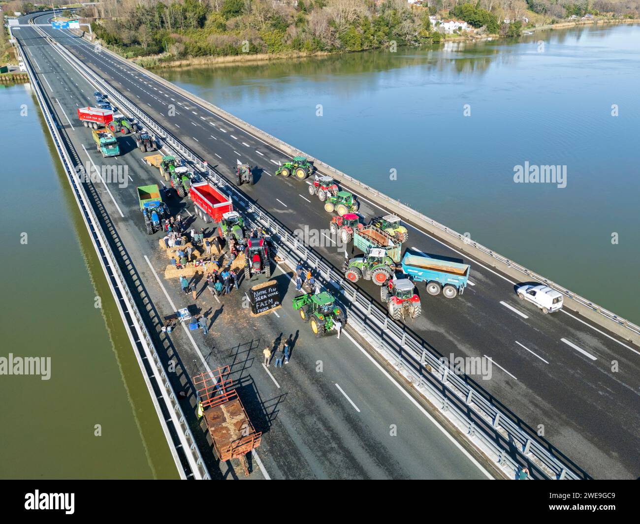 Demonstration of farmers blocking the A63 motorway (Viaduc Hubert Touya, Bayonne (64100), Pyrénées-Atlantiques (64), Nouvelle Aquitaine, France). This Tuesday, January 23, 2024, from 6 a.m., the farmers of the Pyrénées-Atlantiques, at the call of the FDSEA 64 and the Young Farmers, organized blocking points at the Bayonne interchanges. Traffic is interrupted this Tuesday on this portion of the highway by determined protesters. The agricultural demonstrations are a sign of the crisis facing the agricultural sector in France and Europe. Stock Photo