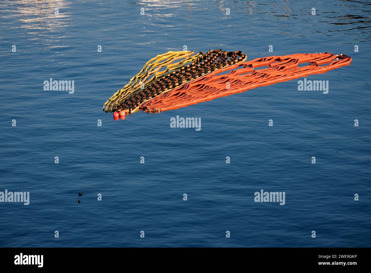 Coiled and folded marker barriers floating on ocean bay Stock Photo Alamy