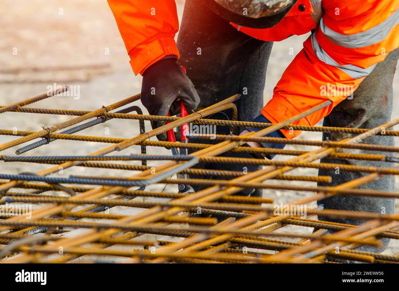 Steel fixer assembling reinforcement cage off rebars. Selective focus Stock Photo