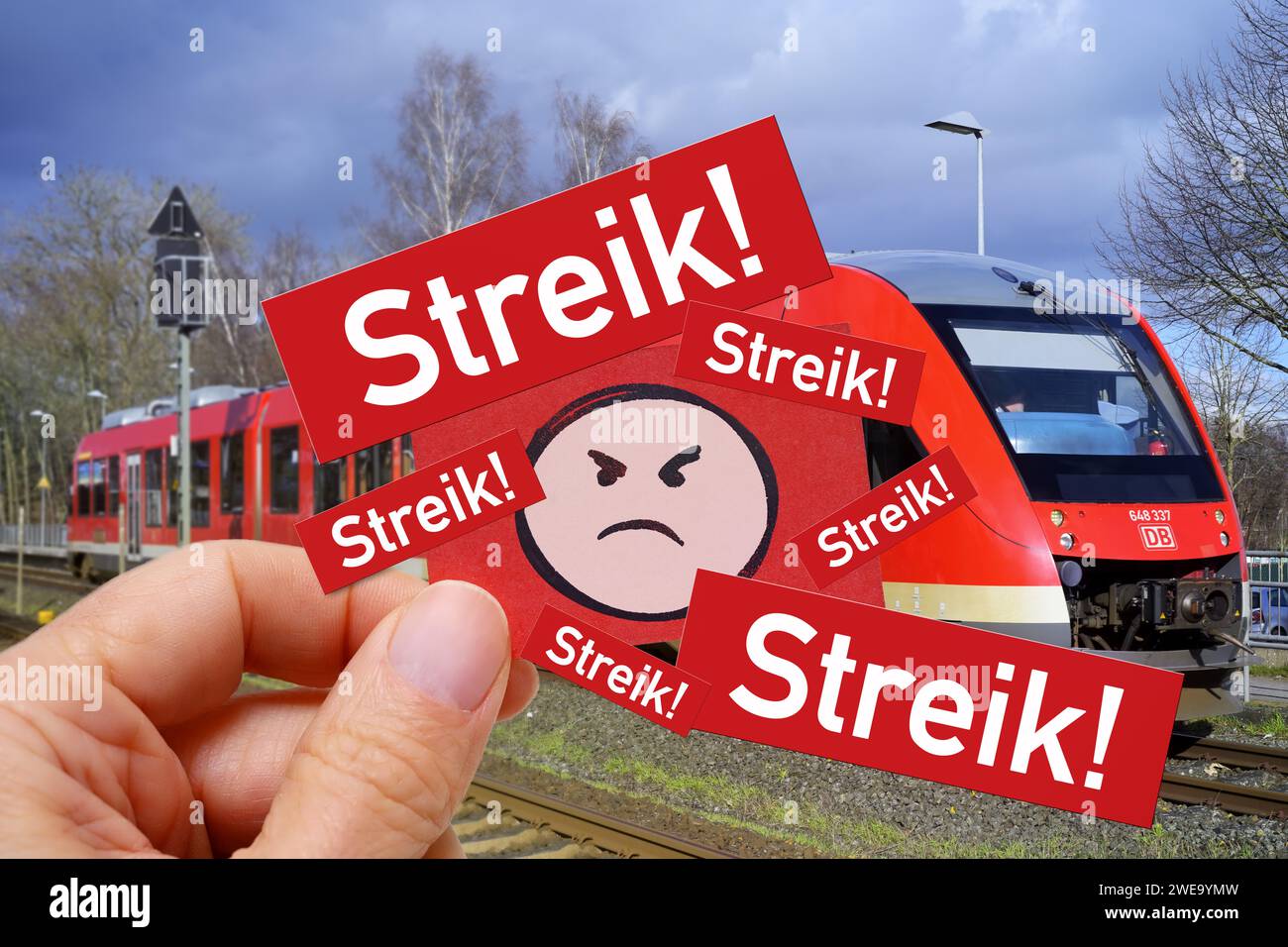 Hand Holds Note With Angry Emoji And Inscription Strike! Before A Train, Symbol Photo Train Strike, Photo Montage Stock Photo