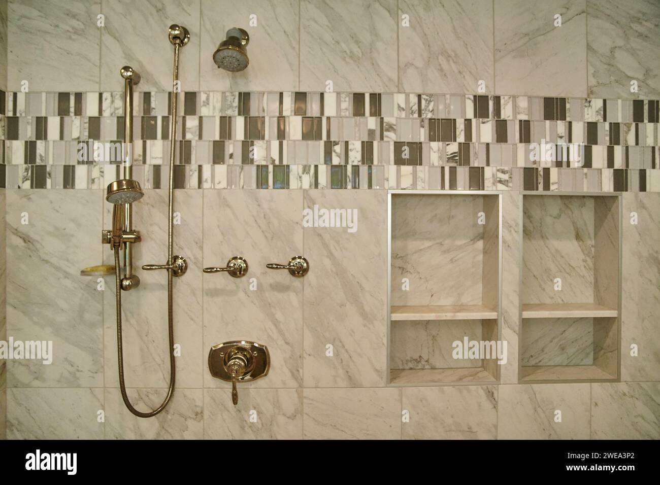 Luxurious Marble Shower with Brass Fixtures and Mosaic Accents Stock Photo