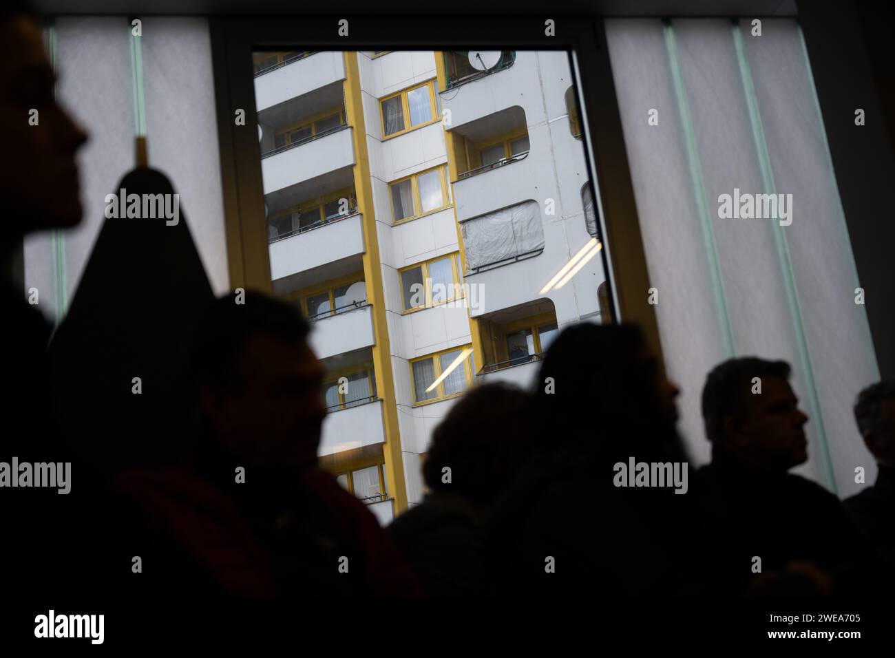 Berlin, Germany. 23rd Jan, 2024. Visitors sit in the Wilhelm Liebknecht/Namik Kemal Central Library at Kottbusser Tor in the Friedrichshain-Kreuzberg district in front of a window in which an apartment building can be seen. Credit: Sebastian Christoph Gollnow/dpa/Alamy Live News Stock Photo