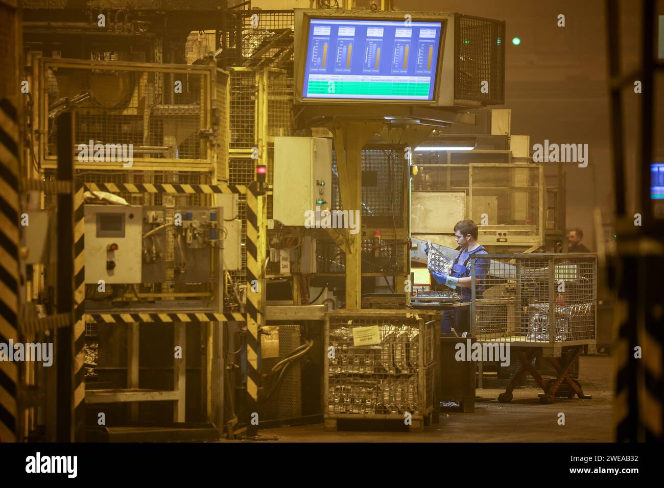 Annaberg Buchholz, Germany. 24th Jan, 2024. Employees of Handtmann Leichtmetallgießerei Annaberg GmbH work on a die-casting machine. 328 employees produce a good 60,000 tons of special cast parts at the site in the Ore Mountains, primarily for the automotive industry. Founded in 1926 as the DKW foundry, parts for MZ motorcycles were manufactured here during the GDR era. After reunification, the company was taken over by the Handtmann Group of Companies from Biberach and further expanded. Credit: Jan Woitas/dpa/Alamy Live News Stock Photo