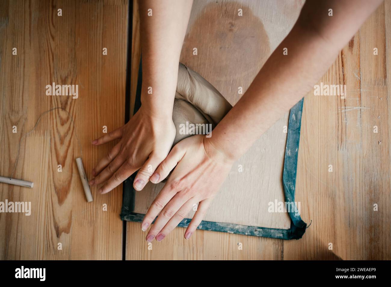 Hands of a ceramist roll out soft, raw white clay Stock Photo