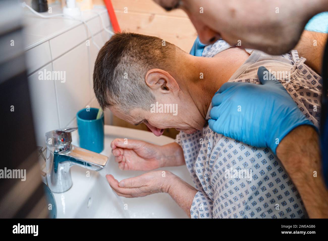 13 November 2022: Nursing service helps a woman in need of care with her personal hygiene in the bathroom *** Pflegedienst hilft einer Pflegebedürftigen Frau im Badezimmer bei der Körperhygiene Stock Photo