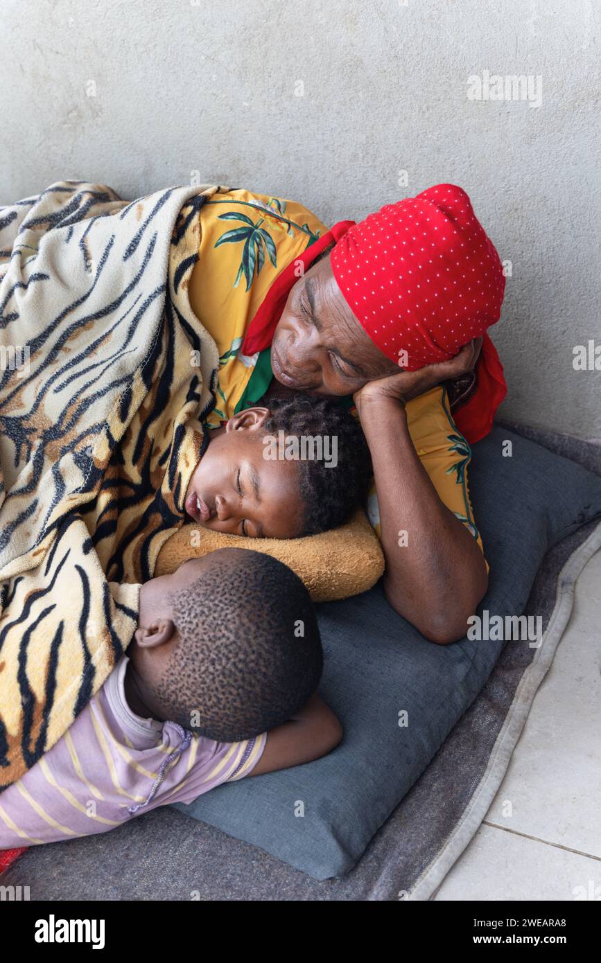 village african family granny and kids sleeping outdoors in front of the house Stock Photo
