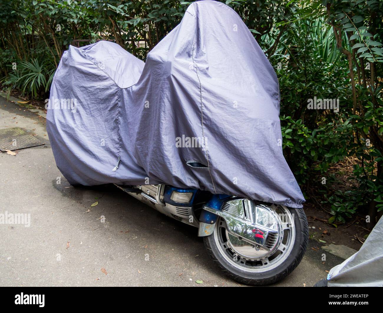 Sochi, Russia - February 12, 2023: The motorcycle stands at the side of the road under a protective awning Stock Photo