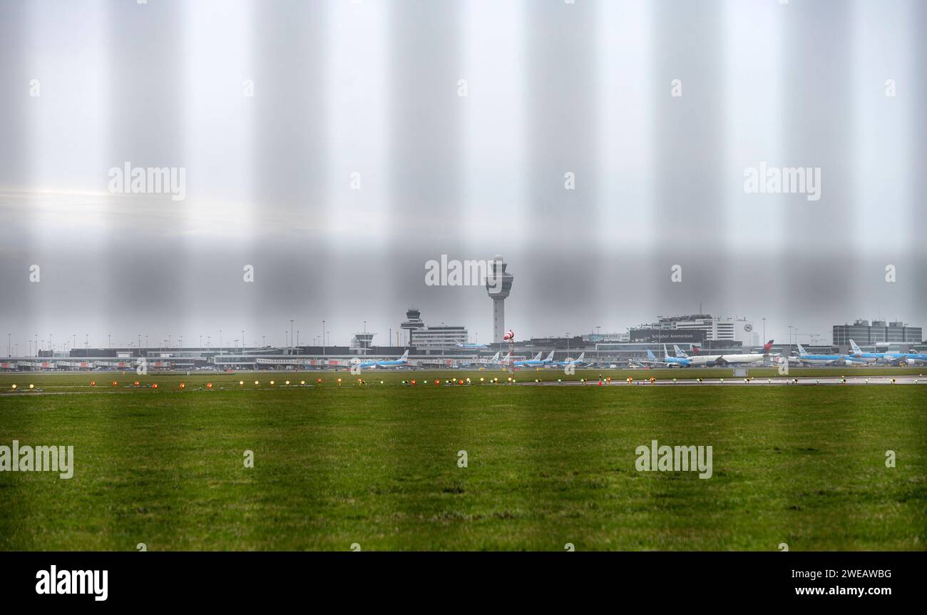 Amsterdam The Netherlands 24th January 2024 Schiphol Airport terminal seen through a perimeter fence dutch, nl, vliegtuig, flugzeug, aankomst, arrival, plane, security, beveiliging, Stock Photo
