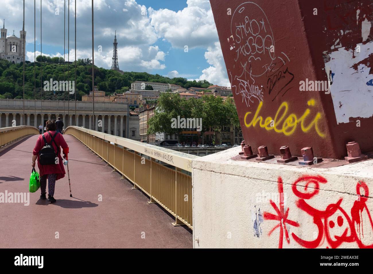 Lyon, France, 2023. A lady crossing the Palais de Justice bridge, with ...