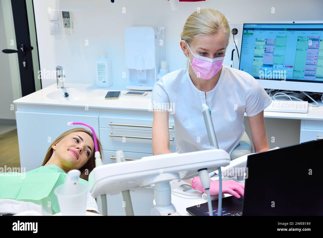 Dentist and patient looking at dental scan on laptop screen. Healthcare And Stomatology Concept Stock Photo