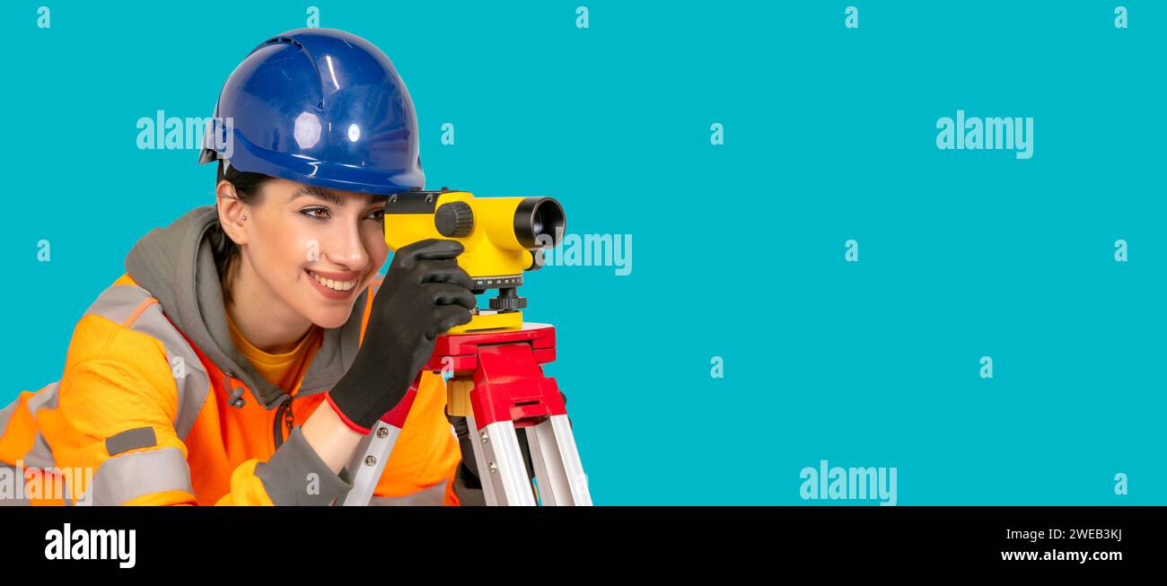woman in hard hat and protective clothes land surveyor working with modern surveying geodesic instrument tachometer checking coordinates. Young woman Stock Photo