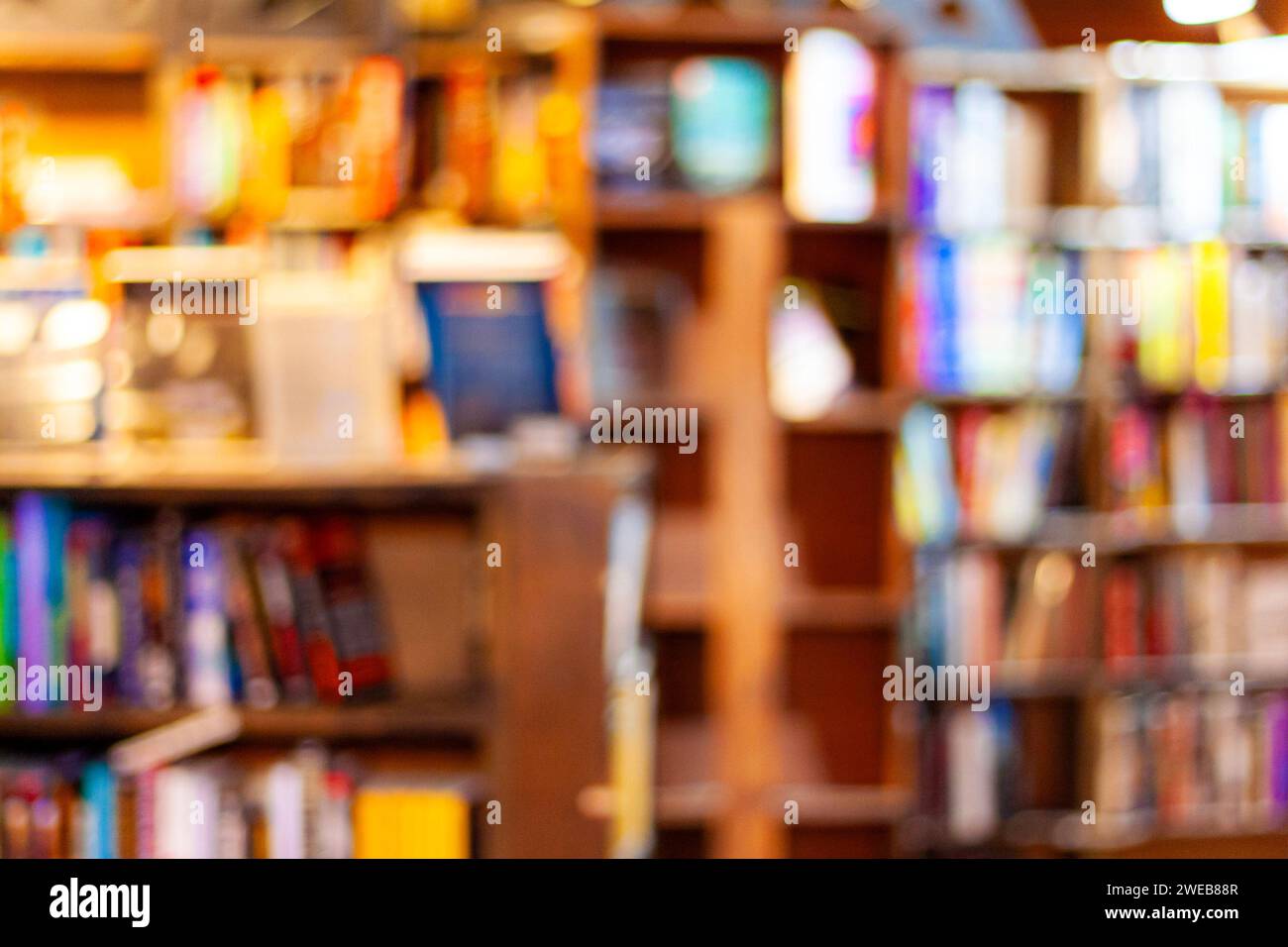 Defocused blurred view of a library, bookstore, or bookshop, literacy concept, abstract background with books on shelves Stock Photo