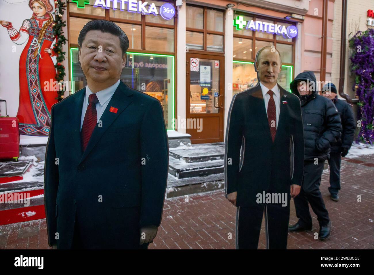 Moscow, Russia. 21st of January, 2024. Russian men walk next to cardboard images depicting Chinese President Xi Jinping (L) and his Russian counterpart Vladimir Putin at the touristic Arbat street in downtown Moscoц, Russia Stock Photo