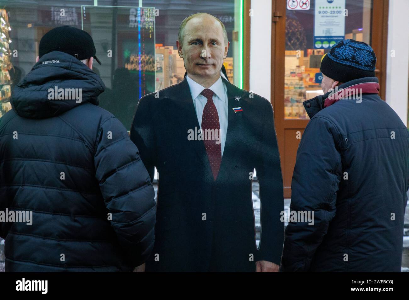 Moscow, Russia. 21st of January, 2024. Men stand next to cardboard image depicting Russian president Vladimir Putin at the touristic Arbat street in downtown Moscow, Russia Stock Photo